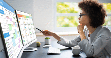 woman at work desk studying charts and graphics on screen